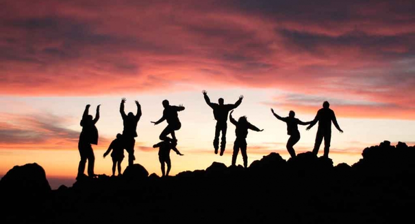 silhouette of teens jumping into the air at sunset